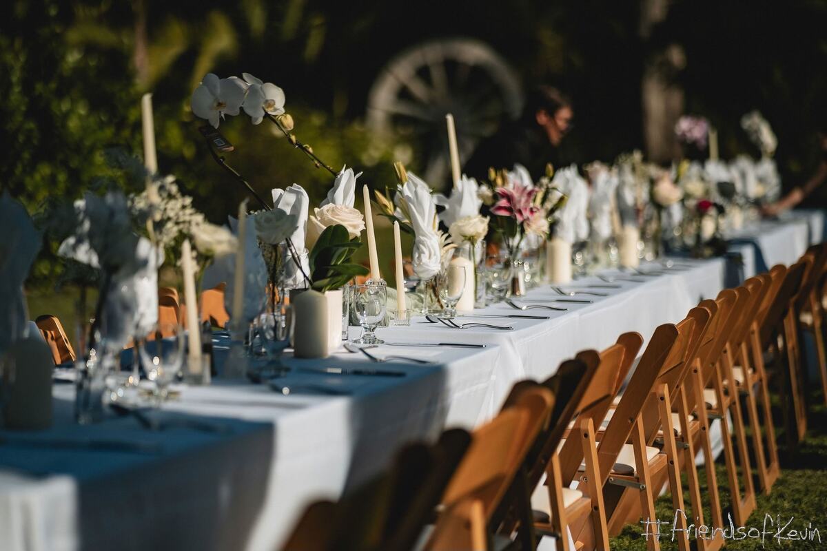 A dinner table set with white flowers and candles